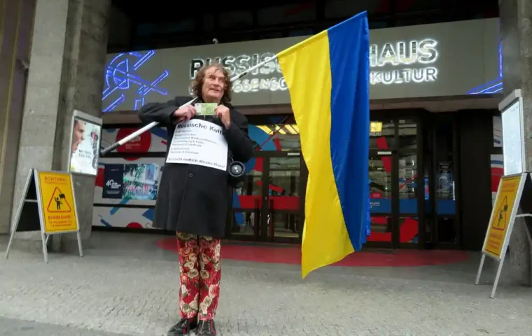 Henry Lindemeier protestiert vor dem Russischen Haus in Berlin mit einer großen ukrainischen Flagge.