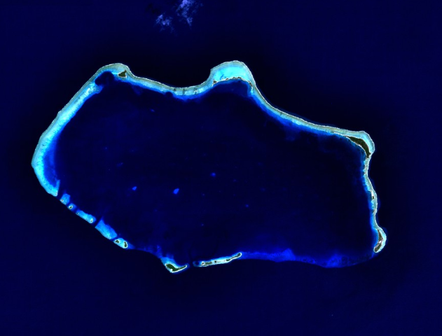 Satellitenaufnahme des Bikini-Atolls mit dem ringförmigen Korallenriff, den schmalen Inseln und der großen Lagune.