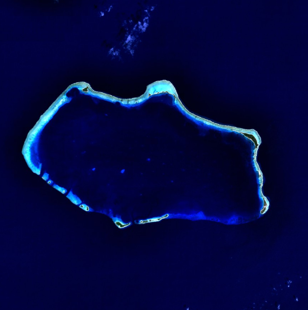 Satellitenaufnahme des Bikini-Atolls mit dem ringförmigen Korallenriff, den schmalen Inseln und der großen Lagune.