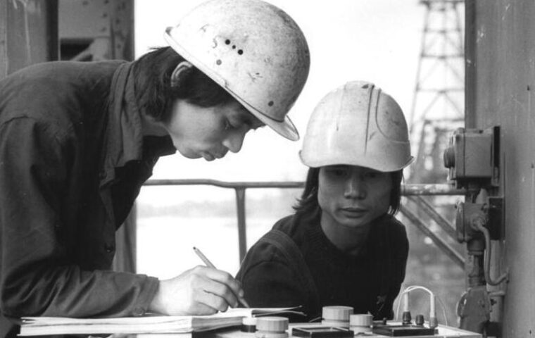 Zwei vietnamesische Vertragsarbeiter bei Arbeiten im Tagebau Jänschwalde in der DDR im Jahr 1982.