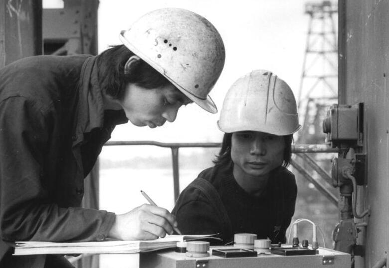 Zwei vietnamesische Vertragsarbeiter bei Arbeiten im Tagebau Jänschwalde in der DDR im Jahr 1982.