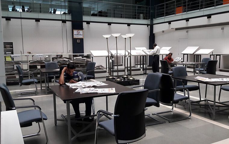 Zeitungsbereich einer Bibliothek mit Leserinnen und Lesern.