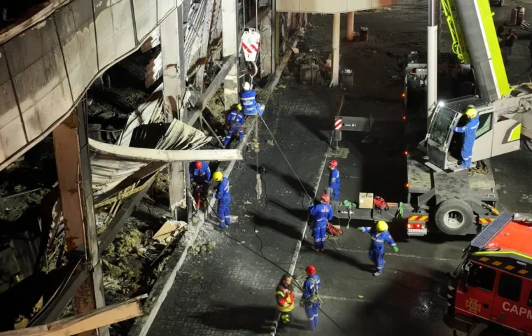 Ukrainische Rettungskräfte arbeiten nachts mit einem Kran an der zerstörten Außenwand des Einkaufszentrums Amstor in Krementschuk