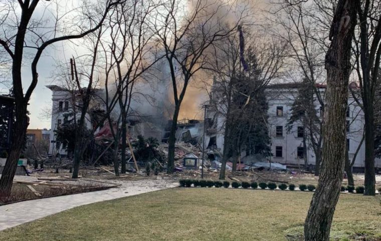The Mariupol Drama Theatre after the 16 March 2022 air strike, showing extensive destruction and smoke over the ruins; no victims are visible.